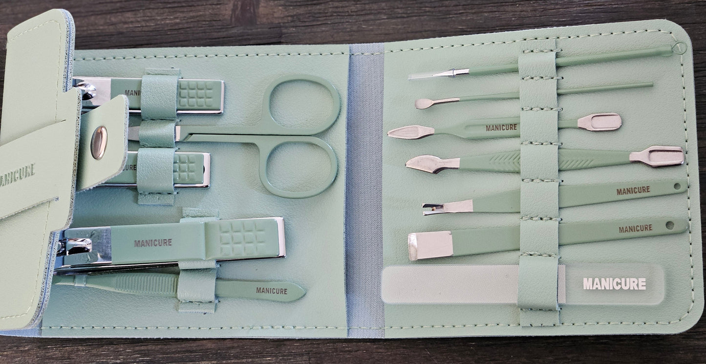 Manicure set with tools in a light green case on a wooden surface