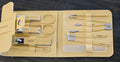 Manicure set with tools in a beige case on a dark background